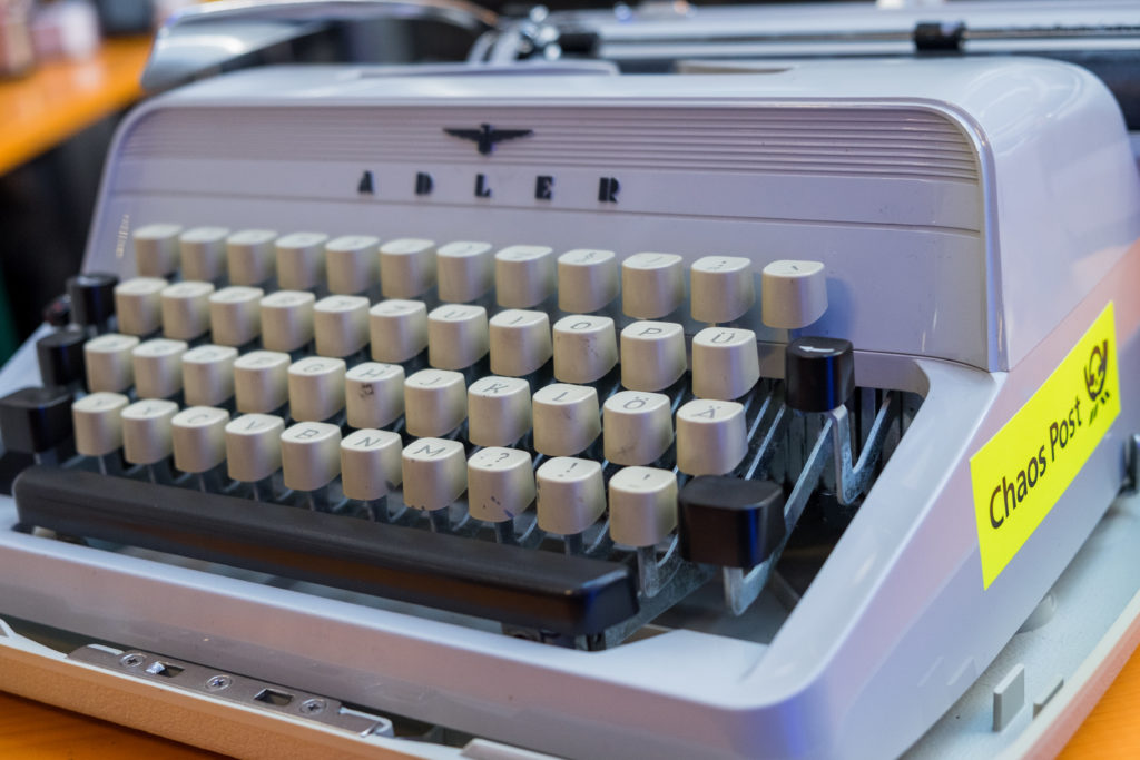Eine uralte „Adler“-Schreibmaschine mit einem „Chaos Post“-Aufkleber an der Seite.