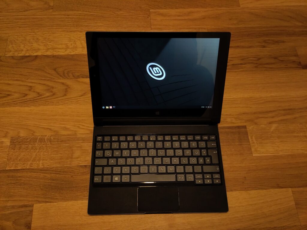 Foto des Tablets verbunden mit der Tastatur. Der Bildschirm zeigt den Linux Mint-Desktop.