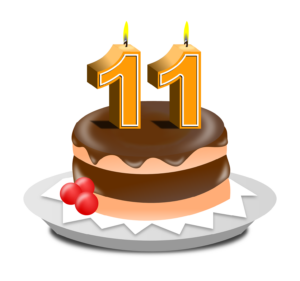 Clipart eines Schokoladenkuchens, auf dem zwei orangefarbene, brennende Kerzen in Form der Ziffer Eins stecken.