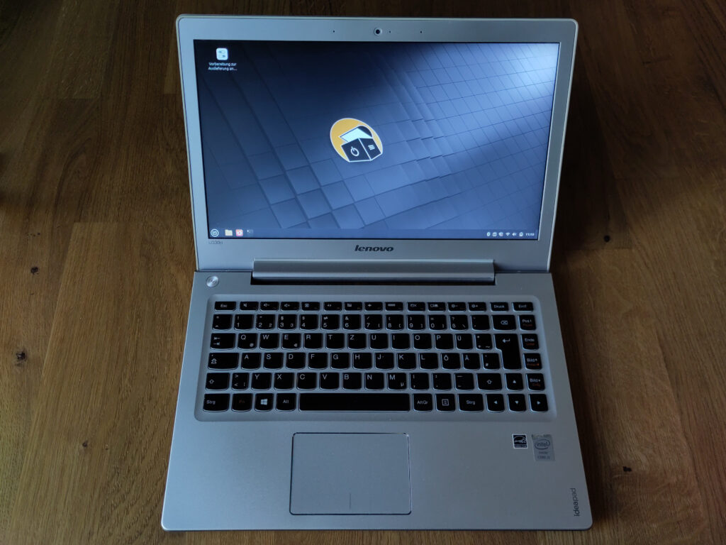 Foto des aufgeklappten Laptops, das den Linux Mint-Desktop anzeigt.
